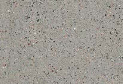Close-up view of a granular gray surface with a fine distribution of black, white, and occasional colored specks.