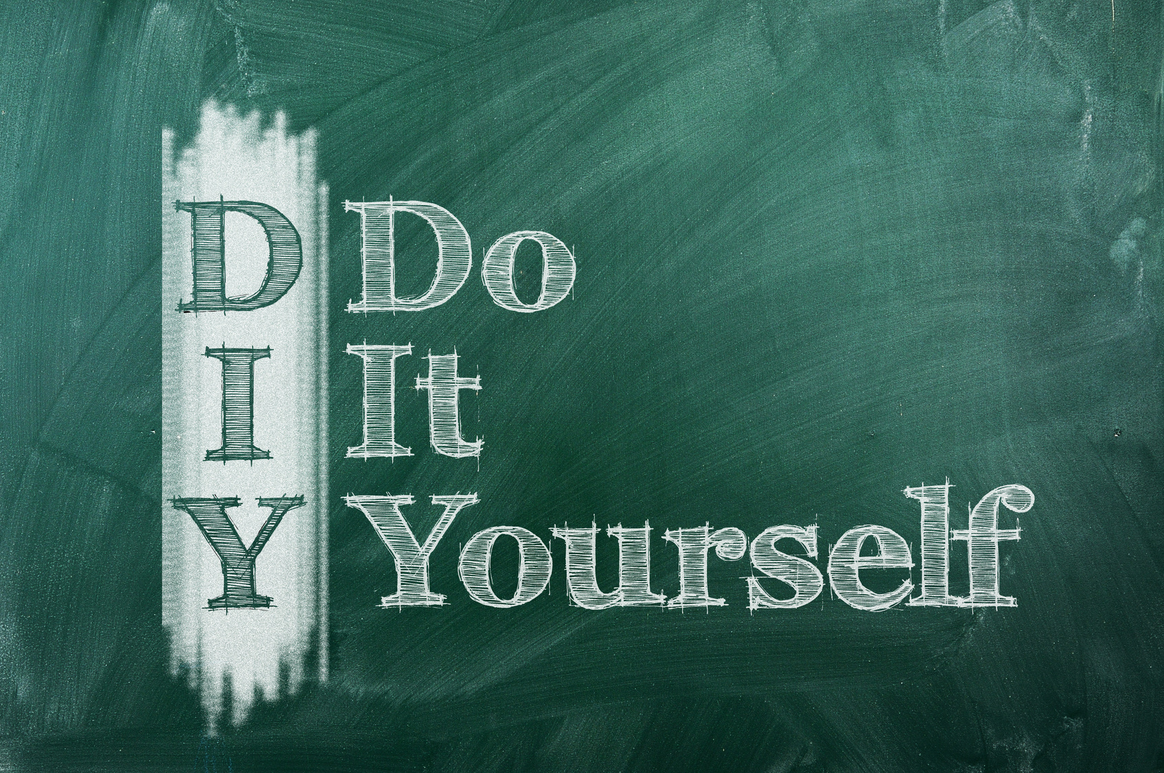 The acronym 'DIY' which stands for 'Do It Yourself,' is written in large white chalk letters on a dark green chalkboard. The first letters of each word are vertically aligned to form the acronym 'DIY' with the rest of the words written to the right, creating an instructional or motivational message often associated with crafting or home improvement projects.